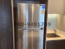 Modern stainless steel refrigerator in a small kitchen with wooden cabinets