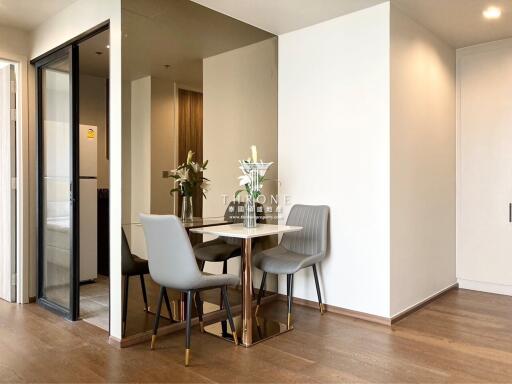 Modern dining area with an elegant table and chairs, hardwood floors, and ample natural light