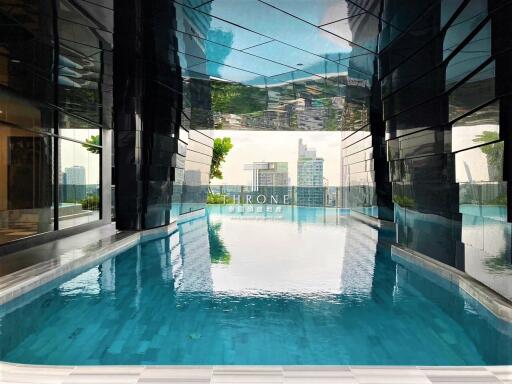 Indoor swimming pool with city view and reflection in the water