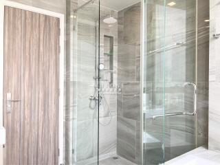 Modern bathroom interior with glass shower and marble tiles