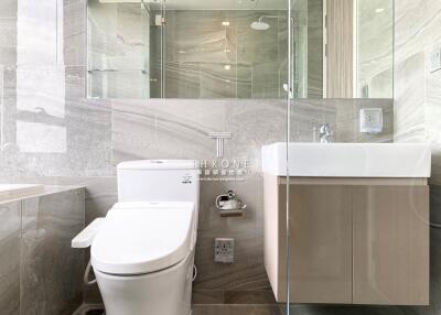 Modern bathroom with marble tiles and glass shower enclosure