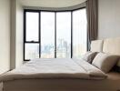 Modern bedroom with a large window offering a city view