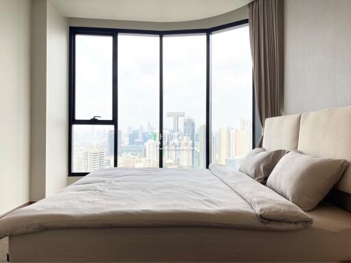 Modern bedroom with a large window offering a city view