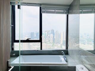 Modern bathroom with city view through large windows