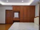 Spacious bedroom with wooden wardrobe and hardwood floors