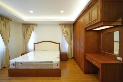 Spacious bedroom with wooden furniture and ample lighting