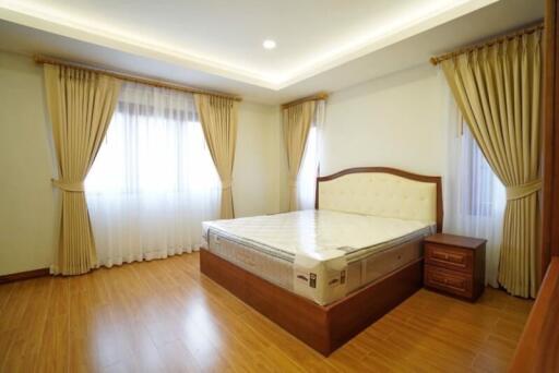 Spacious bedroom with hardwood floors and large bed