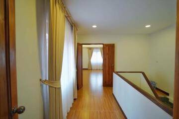 Spacious Hallway with Hardwood Flooring and Natural Light