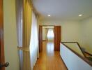 Spacious Hallway with Hardwood Flooring and Natural Light