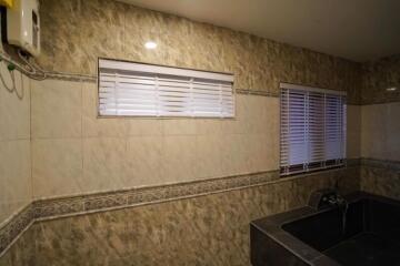 Dimly lit kitchen with tiled walls and modern fixtures
