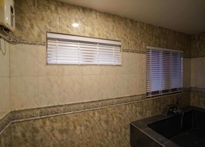 Dimly lit kitchen with tiled walls and modern fixtures