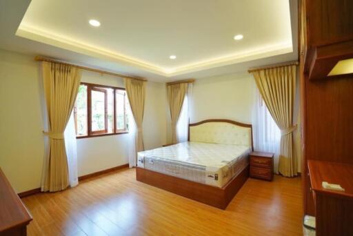 Spacious bedroom with hardwood flooring and large window