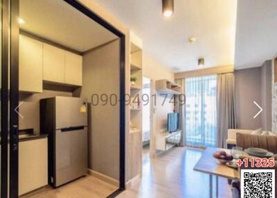 Modern kitchen with stainless steel appliances adjacent to cozy living room with natural light