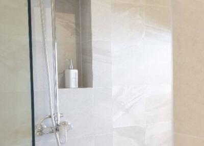 Modern bathroom interior with walk-in shower and beige tiles