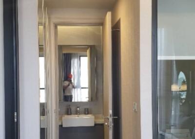 View of a hallway leading to a bathroom inside a modern apartment