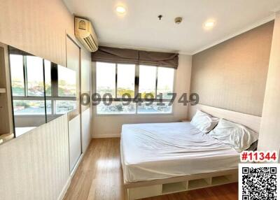 Bright bedroom with large window and wooden flooring