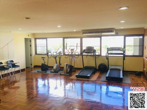 Home gym with fitness equipment and large windows in a residential property