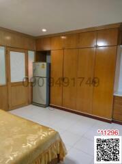Spacious bedroom with large wardrobe and refrigerator