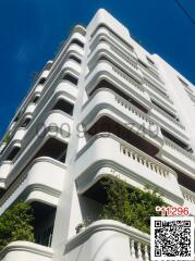 Modern multi-story residential building exterior under clear blue sky