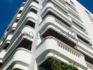 Modern multi-story residential building exterior under clear blue sky