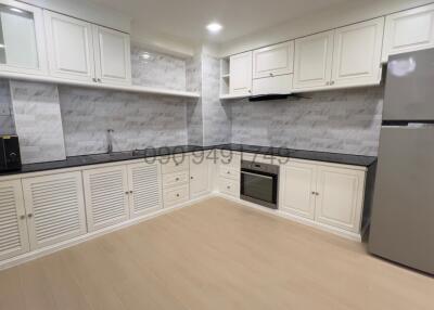 Modern spacious kitchen with white cabinetry and stainless steel appliances