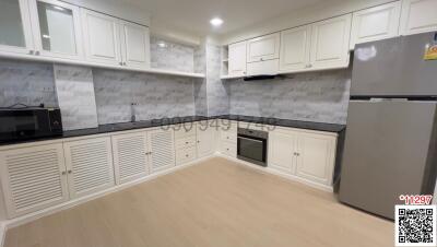 Modern spacious kitchen with white cabinetry and stainless steel appliances