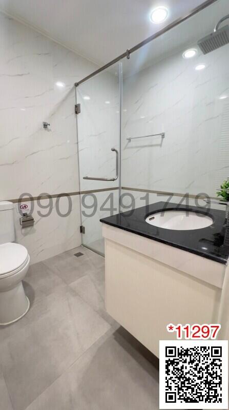 Modern bathroom with glass shower enclosure and marble walls