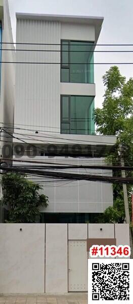 Modern three-story building with large glass windows and a white facade