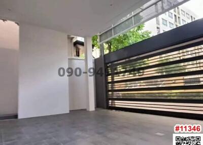 Spacious open-air patio with tiled flooring and a modern metallic fence