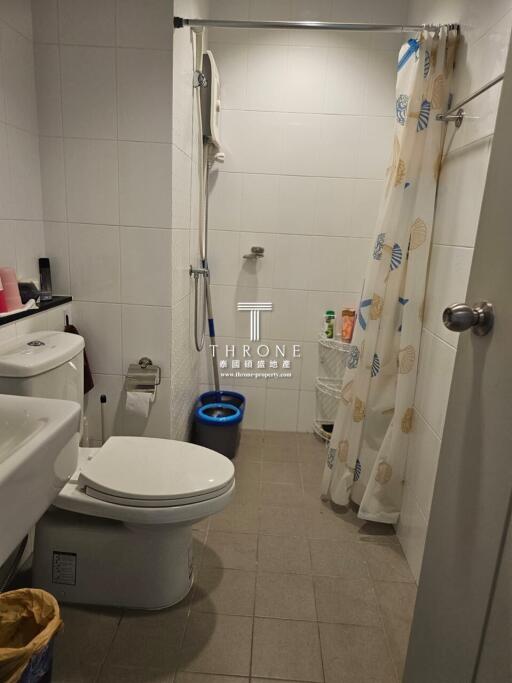 Compact bathroom with toilet, shower, and sink