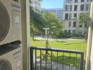 View from the balcony with green lawn and apartment buildings in the background