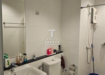 Modern bathroom with white tiles and equipped with shower and wash basin