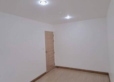 Empty modern bedroom with laminated flooring and recessed lighting