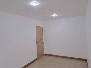 Empty modern bedroom with laminated flooring and recessed lighting