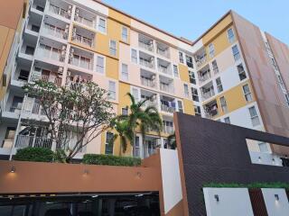 Modern residential apartment building exterior with balconies and parking area