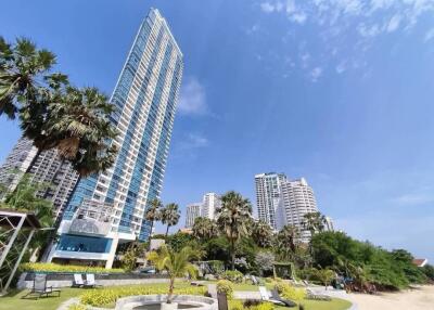 High-rise residential building with landscaped garden under clear blue skies