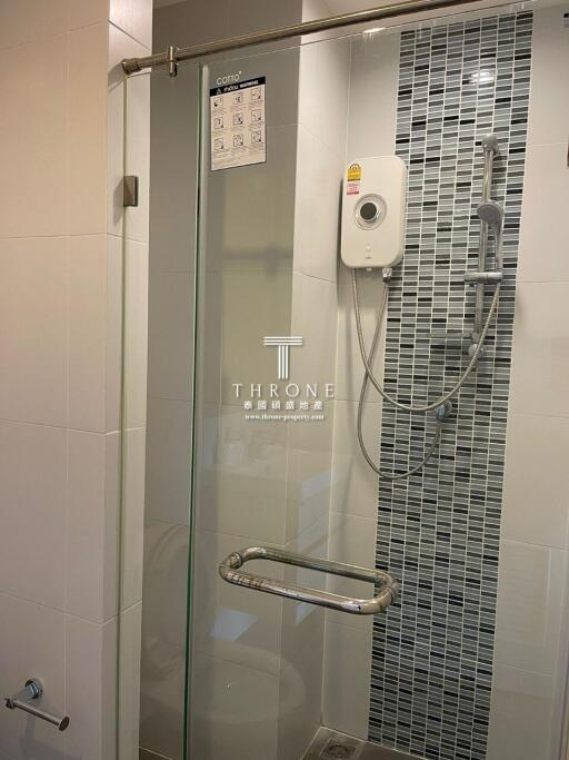Modern bathroom with glass shower door and wall-mounted shower head