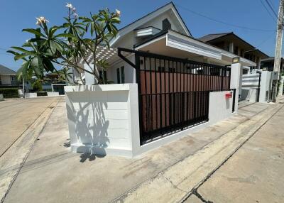 Modern single-family home with white walls and gated entrance