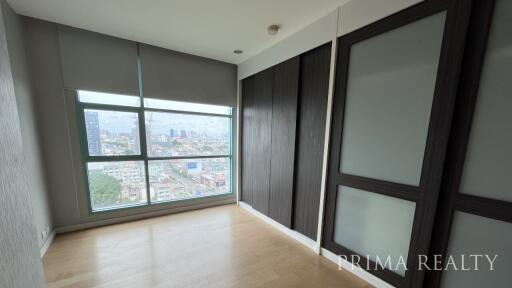 Spacious bedroom with large window and city view