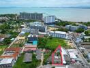 Aerial view of a residential building complex near the coastline with marked property area