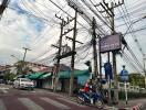 Busy street with electrical power lines and advertising billboard