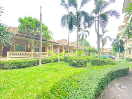 Well-manicured front lawn of a residential building complex with tropical palm trees