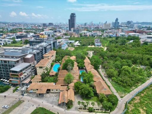 Aerial view of a residential complex with swimming pool and surrounding buildings