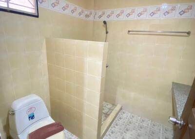 Compact bathroom with yellow tiles and glass shower partition