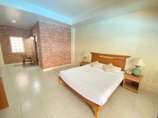 Spacious bedroom with queen sized bed and exposed brick wall