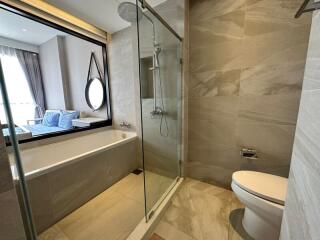 Modern bathroom interior with glass shower cabin, bathtub, and mirror