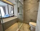 Modern bathroom interior with glass shower cabin, bathtub, and mirror