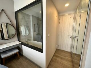 Bright bedroom with reflective sliding wardrobe doors and vanity area