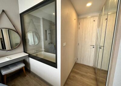 Bright bedroom with reflective sliding wardrobe doors and vanity area