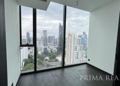 Bright spacious room with floor-to-ceiling windows offering a panoramic city view